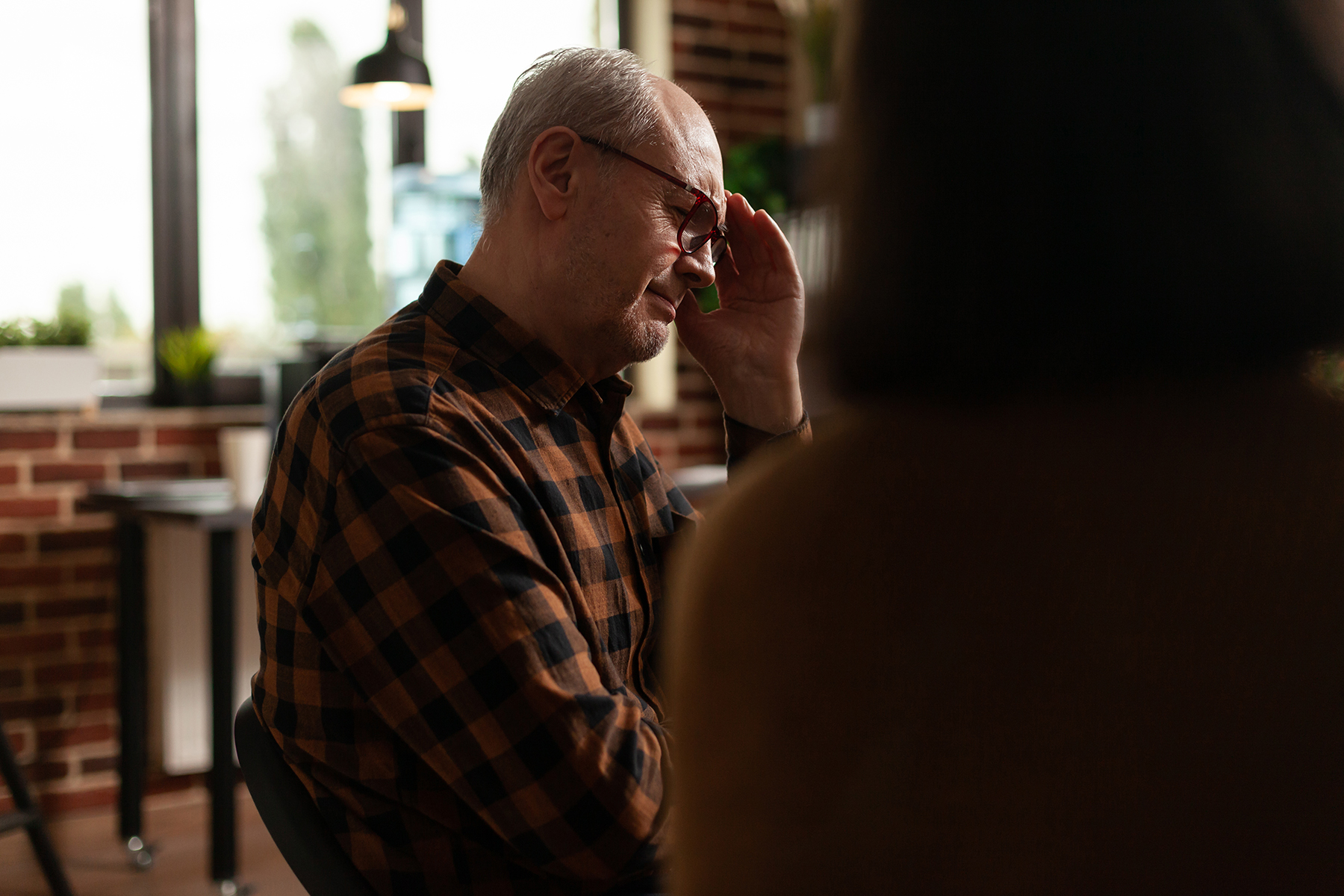 Close Up Of Senior Man Sharing Anxiety Issues With Group At Ther